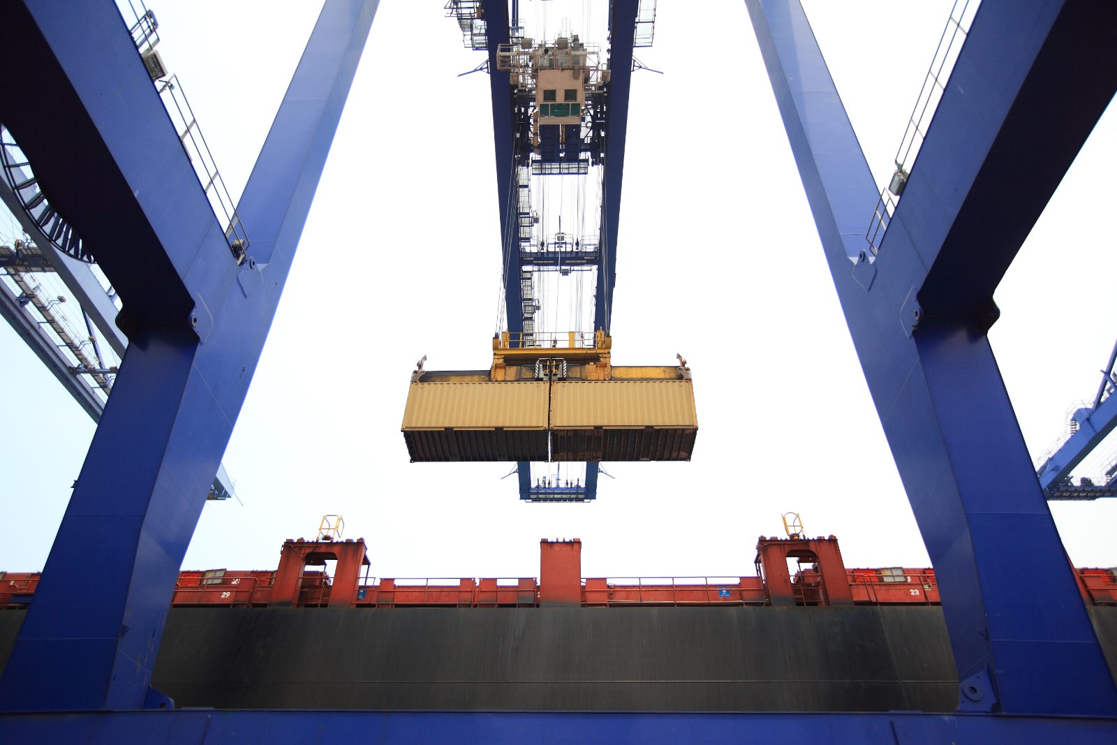 Grue chargeant un conteneur au port, transfert des risques selon les Incoterms 2020